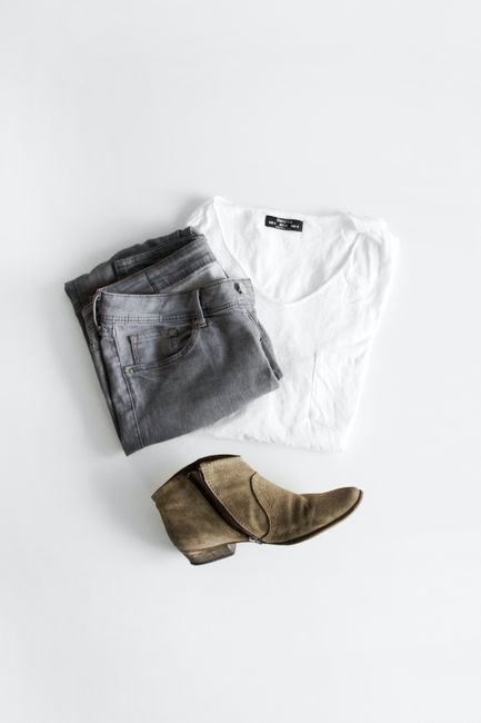 Flat lay of a casual outfit with shirt, jeans, and boot