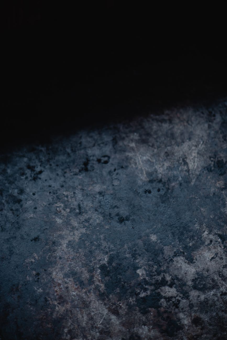 Close-up of a dark raw metal surface texture