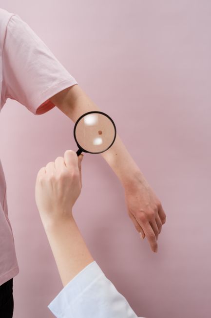 Dermatologist examining skin closely with a magnifier