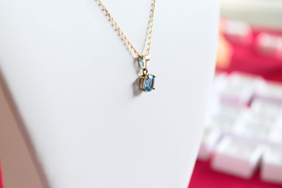 Delicate gold necklace featuring a blue gemstone pendant