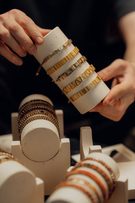 Close-up of hands displaying elegant gold and silver bracelets