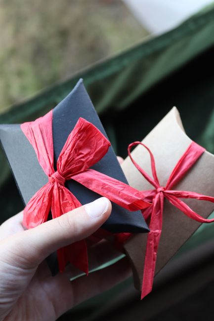 Hand holding two gift boxes wrapped with ribbons