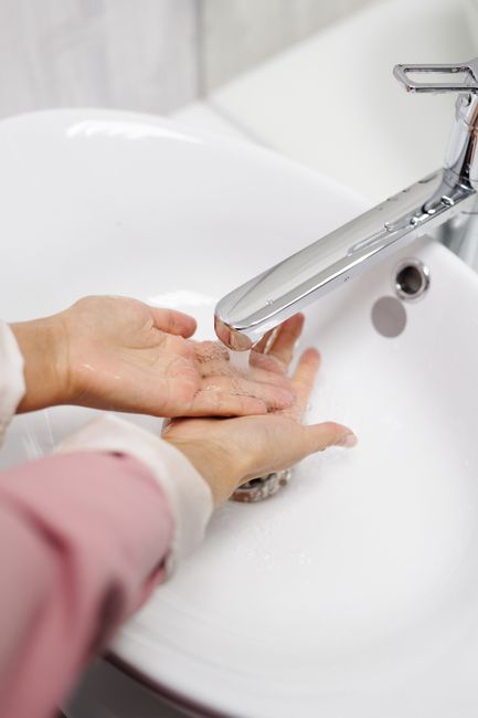 Hands being washed under a faucet with running water