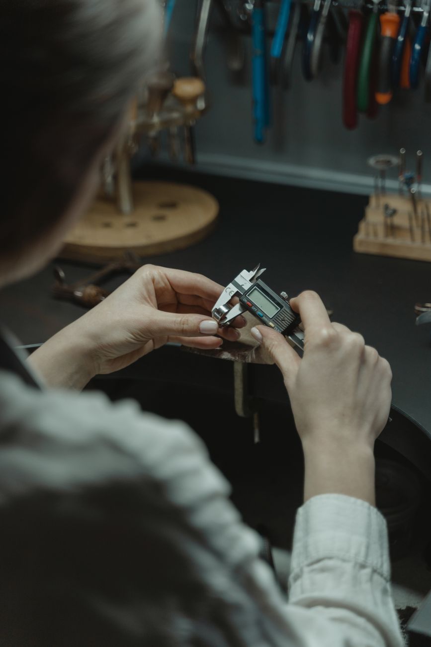 Jeweler using a digital caliper to measure body jewelry