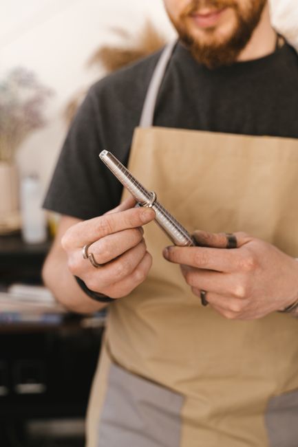 Craftsman measuring ring size with a precision tool in a jewelry workshop