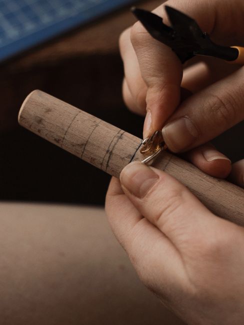 Jeweler shaping a silver ring with a mandrel tool