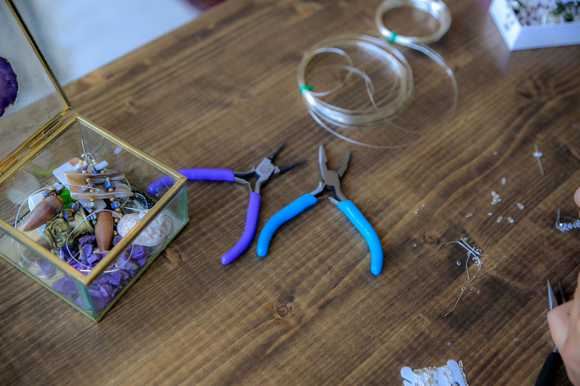 Jewelry-making wire and tools laid out on a workbench