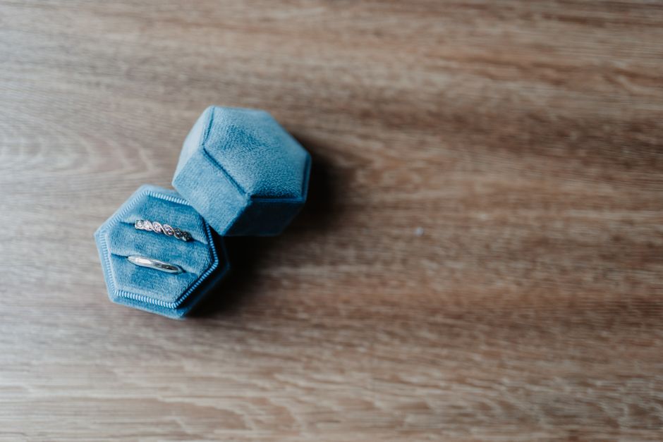 Close-up of rings in a blue velvet jewelry box on a wooden surface
