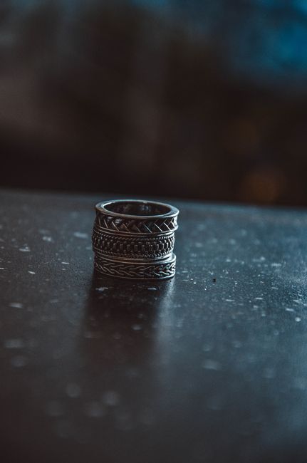 Detailed shot of intricate silver rings stacked on a dark table