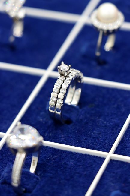 Close-up of silver rings on a velvet display grid