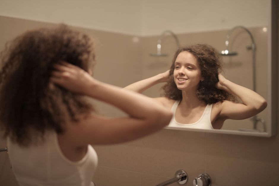 Woman smiling at her reflection in a mirror